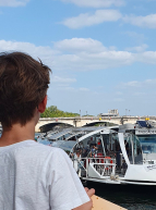 Enfant face à un Batobus sur la Seine