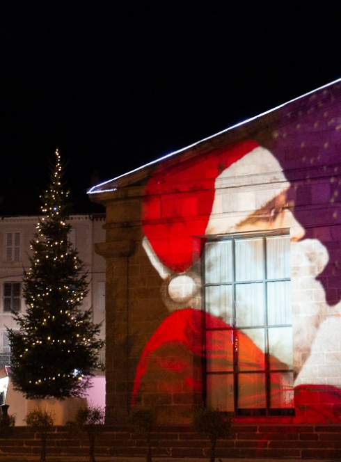 Marchés de Noël à Issoire : Projection lumineuse du Père Noël sur un mur et sapin de Noël
