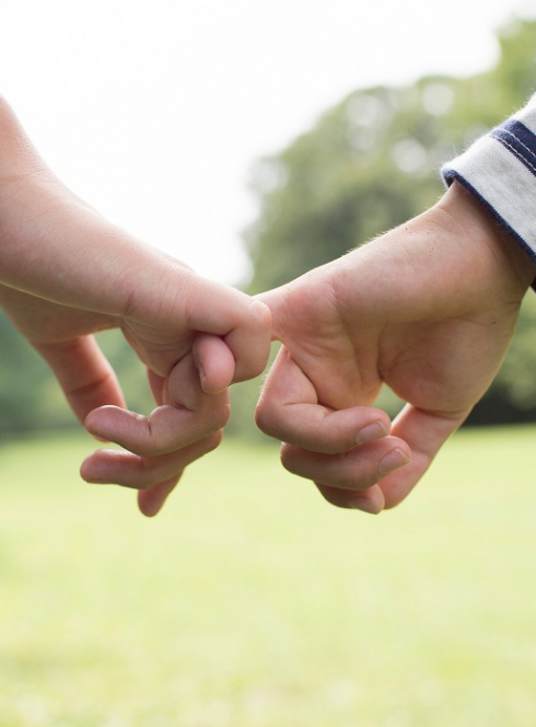 Journée de la Petite Enfance à Roubaix : Un adulte et un enfant se tiennent par les petits doigts