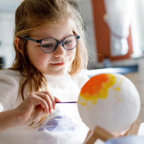 Festival Astro'Valberg : Une petite fille peint une sphère pour représenter une planète