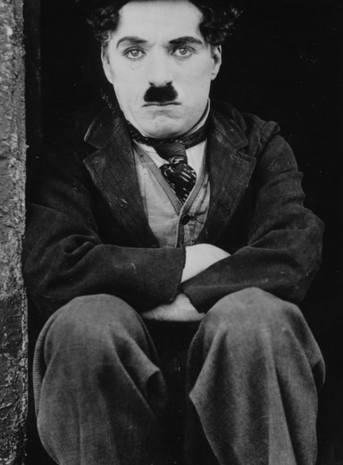 Expo The Kid : Image du film avec Charlie Chaplin assis à côté d'un enfant