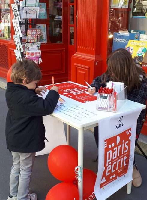 L'Émile : enfants écrivent devant la librairie