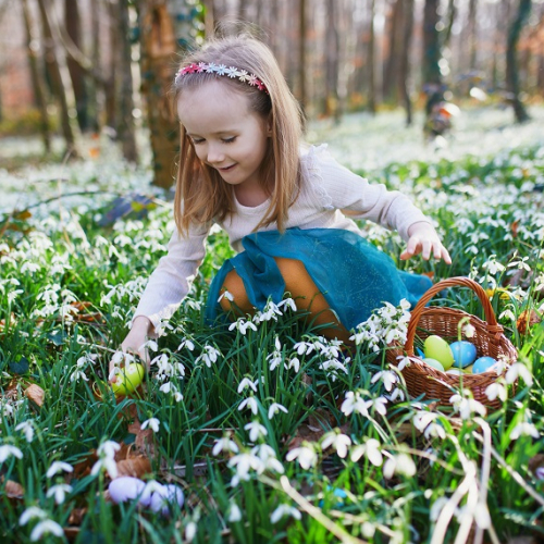 Chasses aux œufs de Pâques 2024 autour de Lille : petite fille qui ramasse des œufs colorés dans les bois