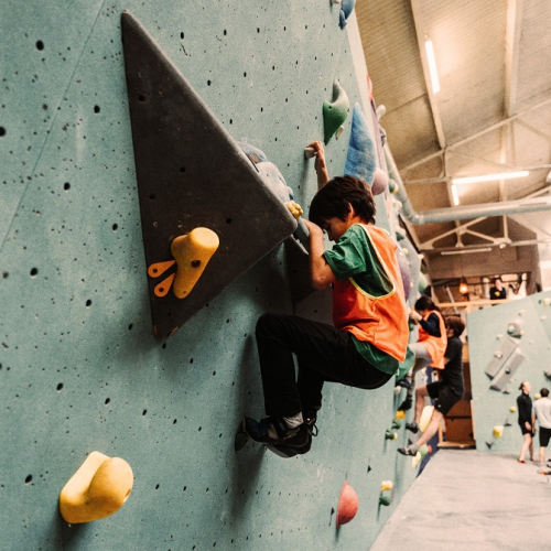 Arkose Lille : Un petit garçon grimpe sur un mur d'escalade
