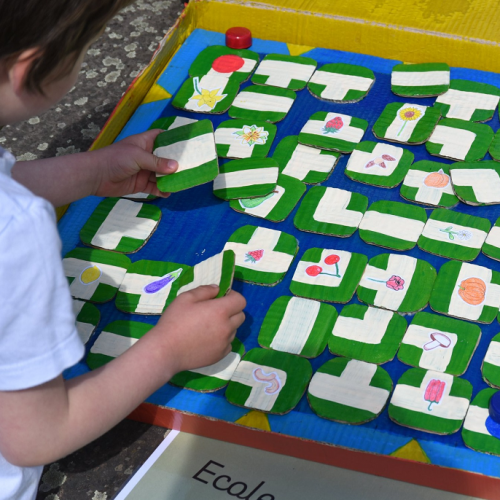 Nature en ville : Un enfant s'amuse grâce à un jeu de plateau fait main