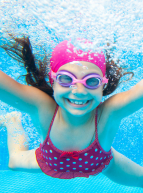 Une fillette se baigne dans une piscine sous l'eau