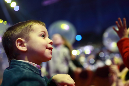 Enfant qui sourit devant un spectacle