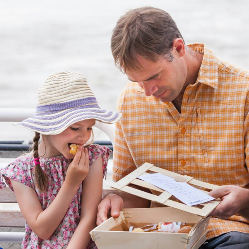 Croisière sur l'Erdre : Une petite fille et son papa grignotent sur un bateau