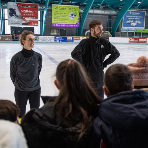 Les animations d'automne à la patinoire de Clermont-Ferrand : Deux patineurs professionnels sur la glace devant des enfants