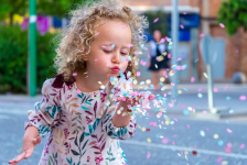 Adobe Stock - petite fille qui souffle sur des confettis