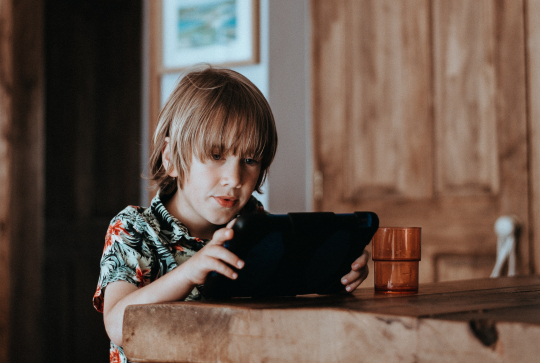 Des jeux éducatifs avec Dynseo : enfant avec une tablette