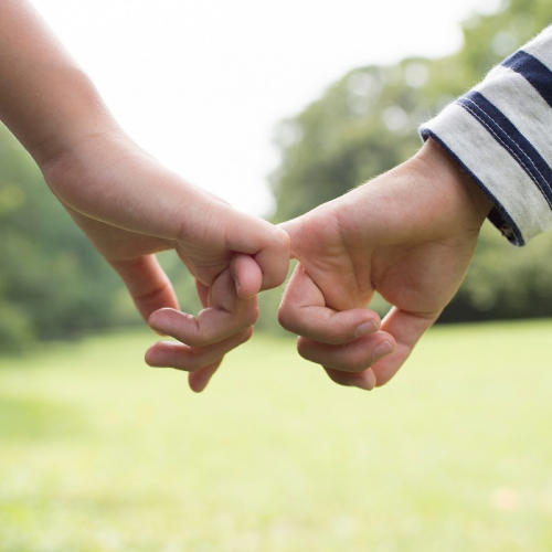 Journée de la Petite Enfance à Roubaix : Un adulte et un enfant se tiennent par les petits doigts