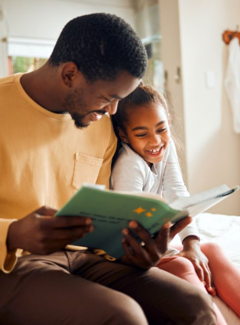 Un père et sa fille en train de lire