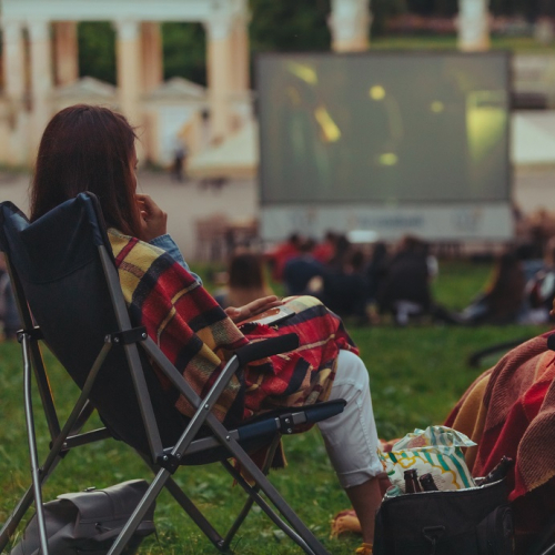 Cinéma plein air à Nice : Une couple regarde un film dehors sur des chiliennes