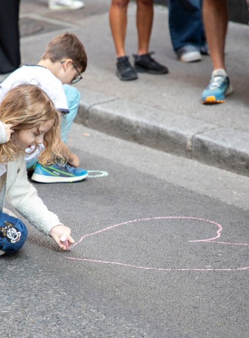 Ateliers vacances au Musée de l'Imprimerie et de la communication graphique de Lyon : Une petite fille et un petit garçons dessinent à la craie sur le sol