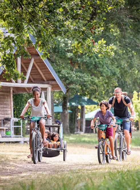 Famille à vélo dans un Village Huttopia