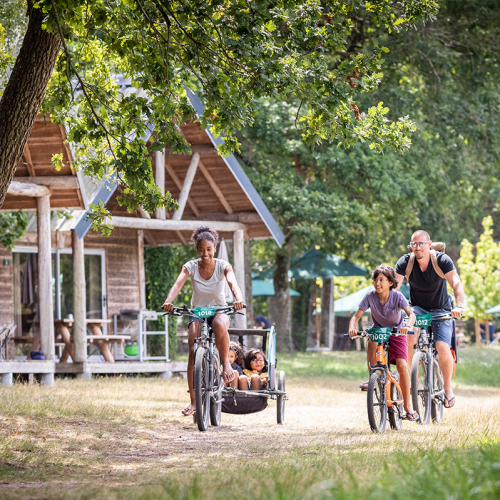 Famille à vélo dans un Village Huttopia