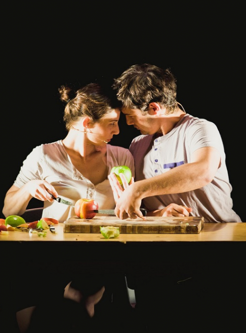 Jonathan & La Table Bleue - Ari Teperberg et Inbal Yomtovian : Deux personnes sur scène collent leurs fronts l'un contre l'autre devant une table avec plein de légumes