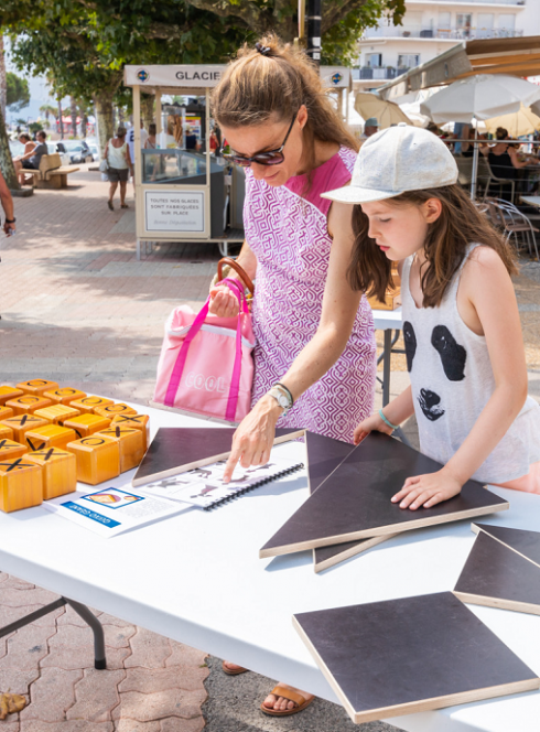 Mômes en fête : Une petite fille et sa mère joue à un jeu de logique au bord de la mer