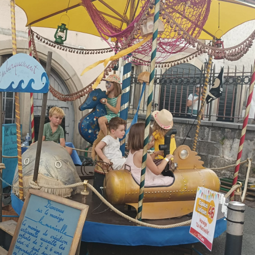 Festival des Mômes : des enfants sur un petit manège d'antan