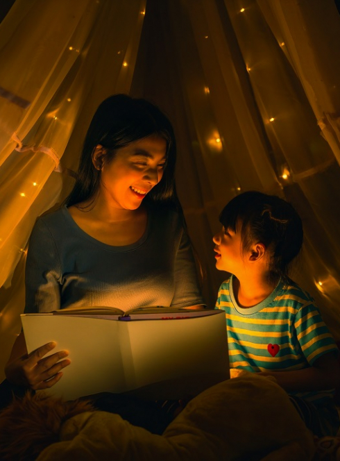 Les Nuits de la lecture : Une mère et sa fille lisent un livre sous une tente