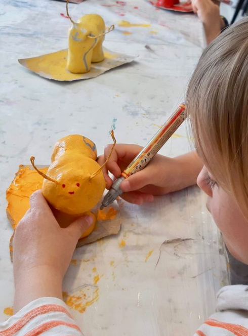 La petite académie de Tassin : Un enfant peint une petite chenille en papier