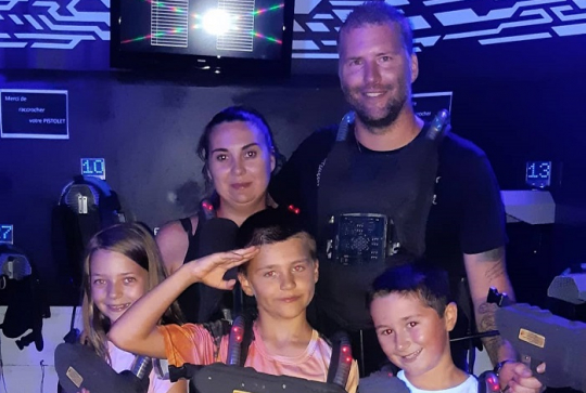 Laser Game Evolution Nice : Une famille pose après avoir fait une partie
