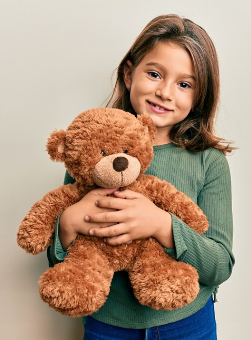 Léon l'ourson et Peter l'oiseau migrateur - Amélie Abrieu : Une petite fille tient dans se bras un ourson en peluche