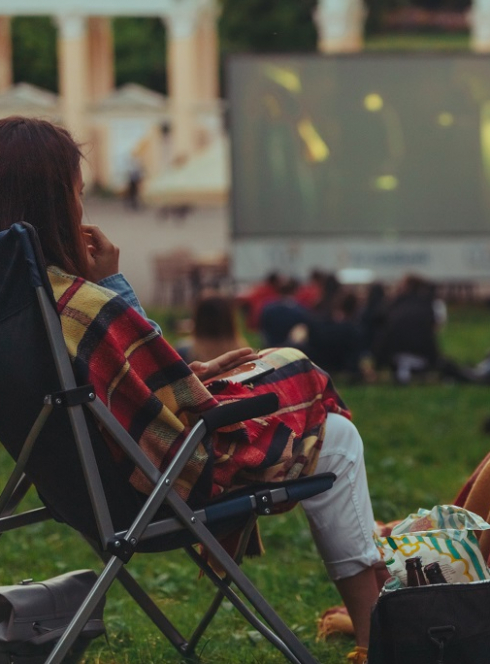 Cinéma plein air à Nice : Une couple regarde un film dehors sur des chiliennes