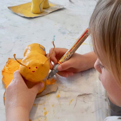 La petite académie de Tassin : Un enfant peint une petite chenille en papier