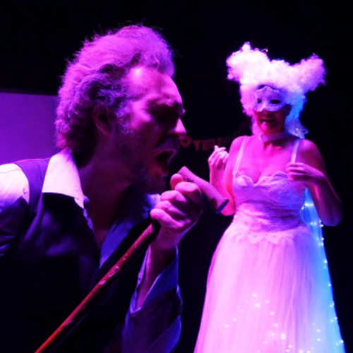 Scrooge - Compagnie Loup de Lune : Un chanteur et une comédienne sous une lumière violette