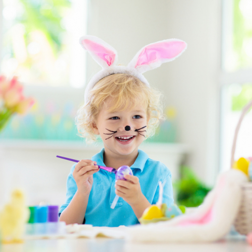 Enfant qui peint un oeuf de Pâques