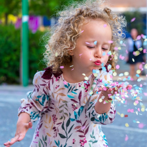 Adobe Stock - petite fille qui souffle sur des confettis
