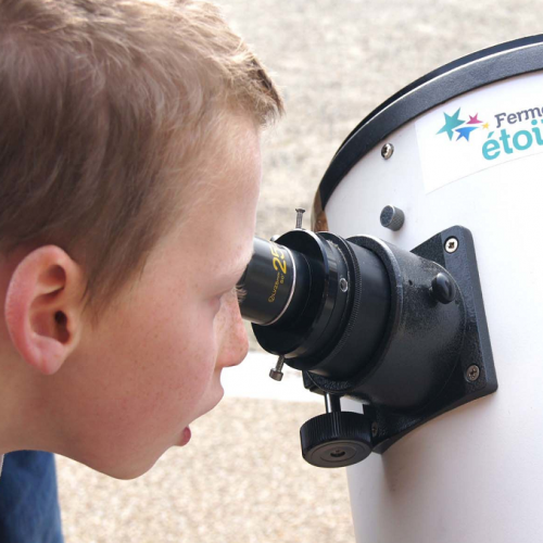 Festival d'Astronomie : Un petit garçon observe le ciel grâce à un instrument optique