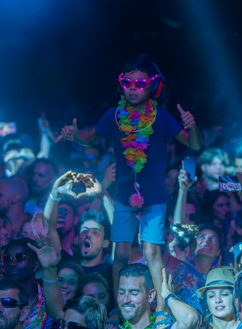 Family Piknik : Un petit garçon debout sur les épaules de son père profite d'un concert électro