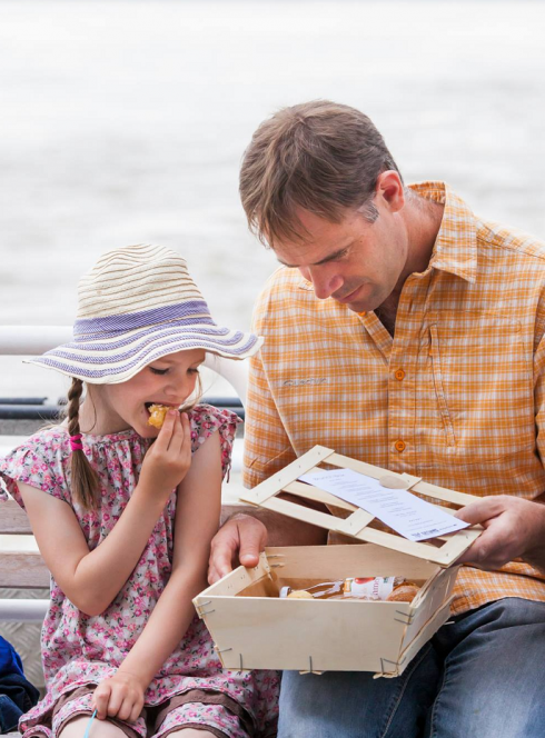 Croisière sur l'Erdre : Une petite fille et son papa grignotent sur un bateau