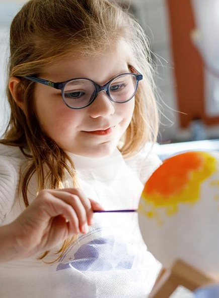 Festival Astro'Valberg : Une petite fille peint une sphère pour représenter une planète