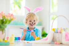 Enfant qui peint un oeuf de Pâques